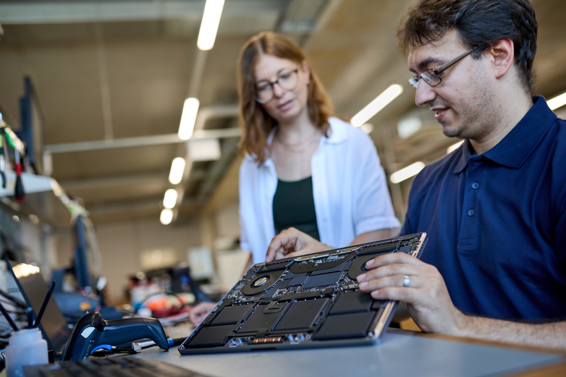 Das Bild zeigt afb Mitarbeiter, die ein Notebook auseinanderbauen, um es zu prüfen