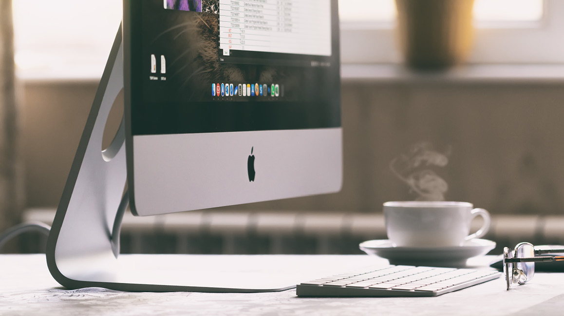 Das Bild zeigt einen Apple iMac auf dem Schreibtisch