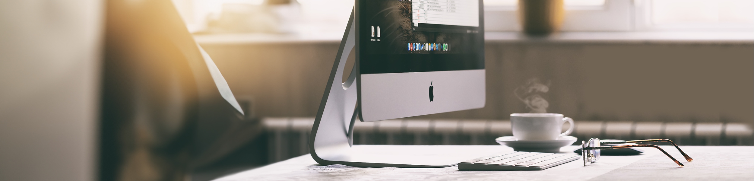 das Bild zeigt einen iMac auf einem Schreibtisch