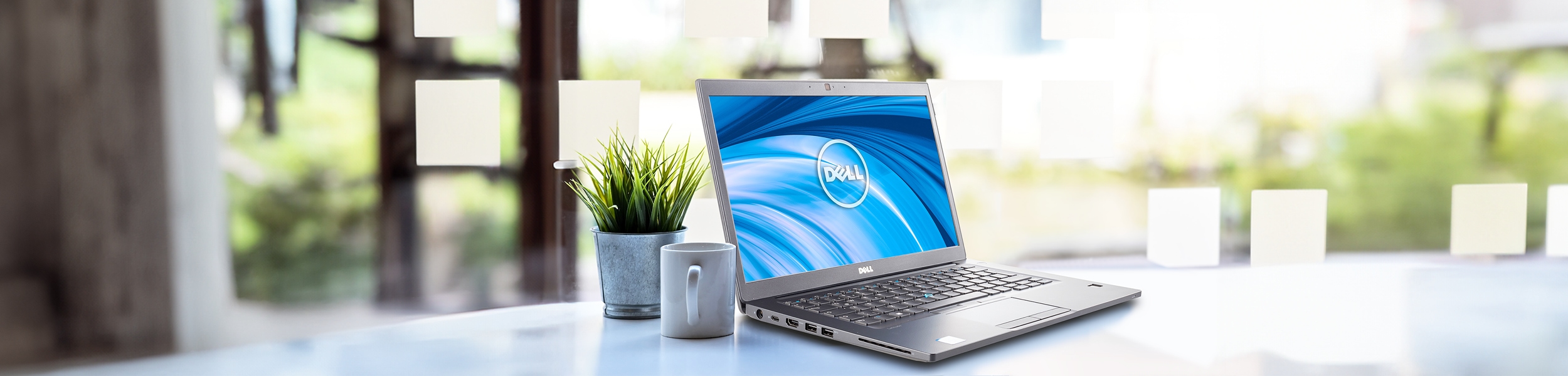das Bild zeigt ein eingeschaltetes Dell Latitude Notebook auf einem Schreibtisch