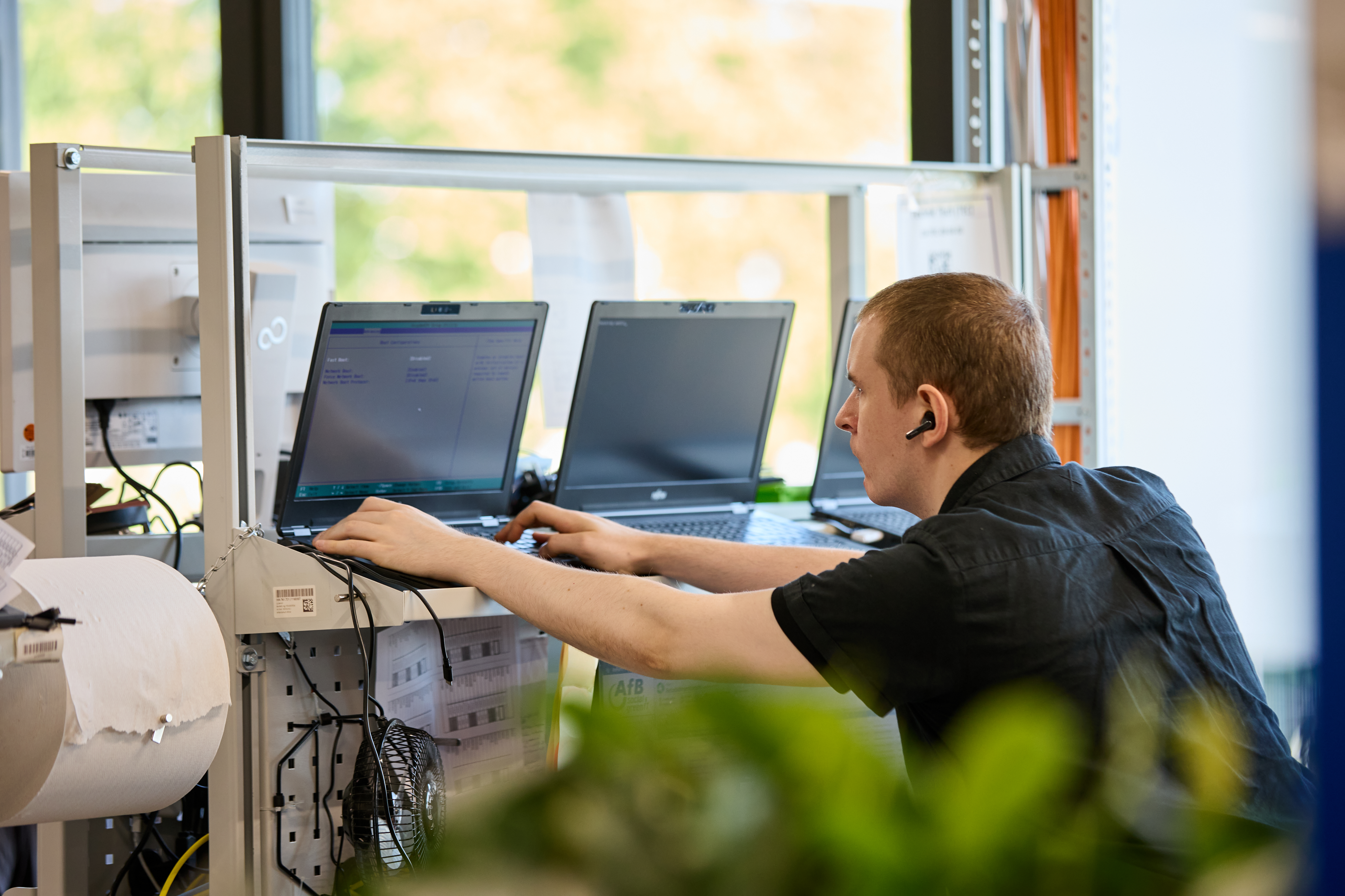 Das Bild zeigt einen afb Mitarbeiter, der einen Notebook-Qualitätscheck durchführt